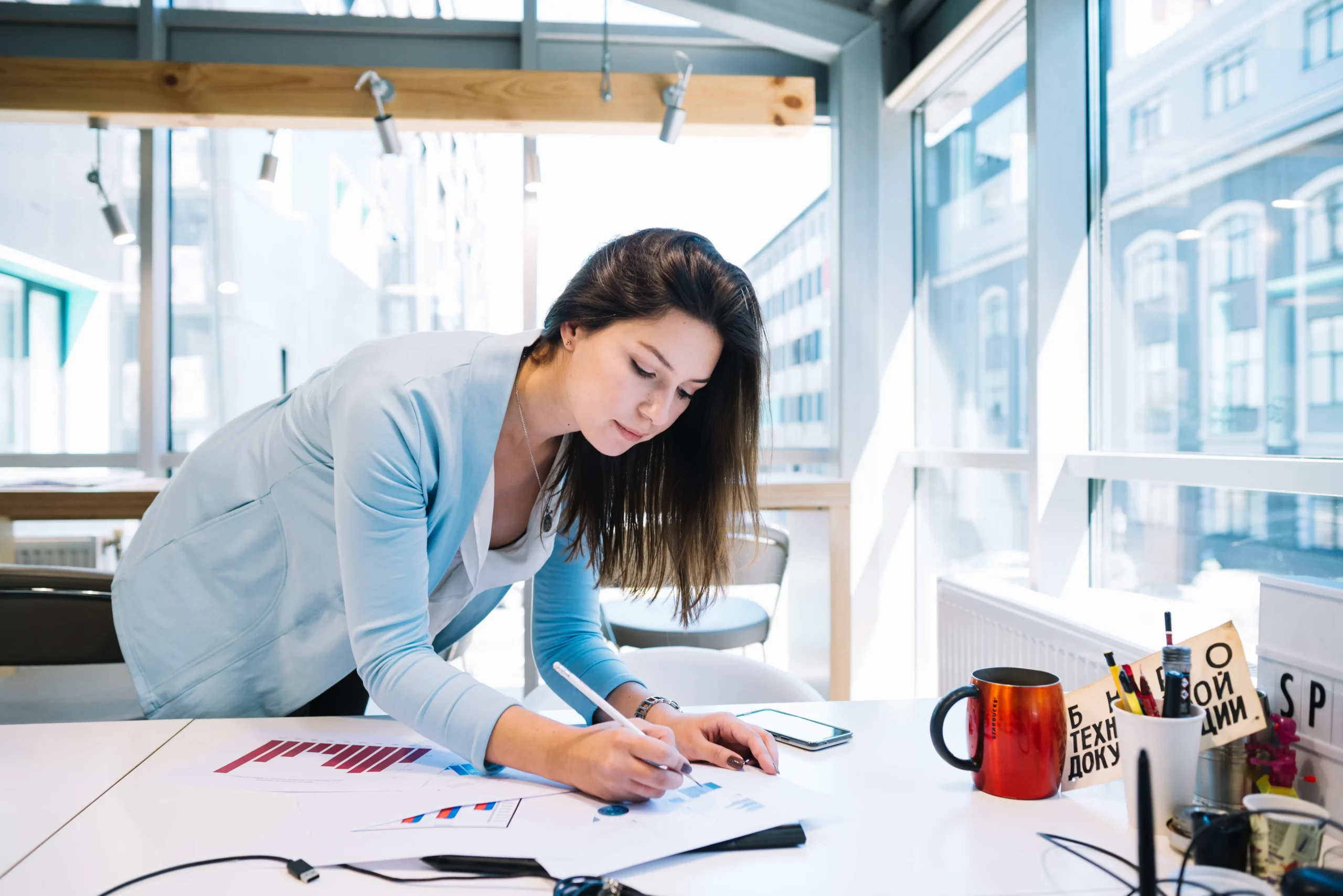 woman-correcting-charts-near-window